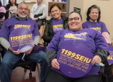 several people  with 1199SEIU signs indoors
