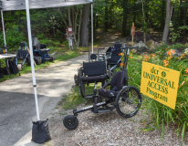 Hiking path with DCR Universal Access Program sign and several chairs for accessible hiking