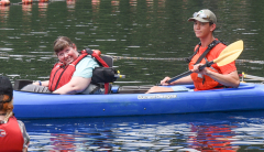 Woman smiling in kayak with DCR staff