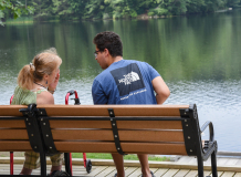 Two people on a bench in front of the pond