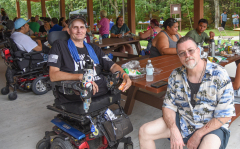 two men sitting at picnic table