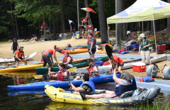 People getting into kayaks on the beach