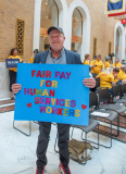 Man with sign "Fair Pay for Human Services Workers"