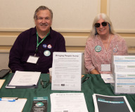 Paul Lanzikos and Sue at Dignity Alliance MA table