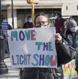 Anne Fracht with sign "Move the Light Show"