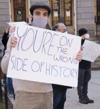 Man with sign: You're on the wrong side of history