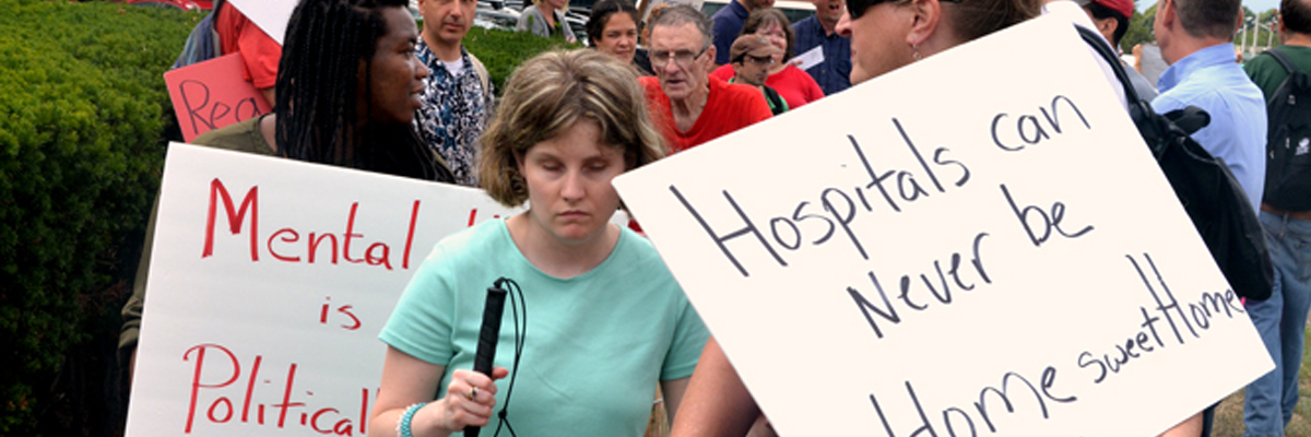 demonstrators - signs say Hospitals can never be Home Sweet Home