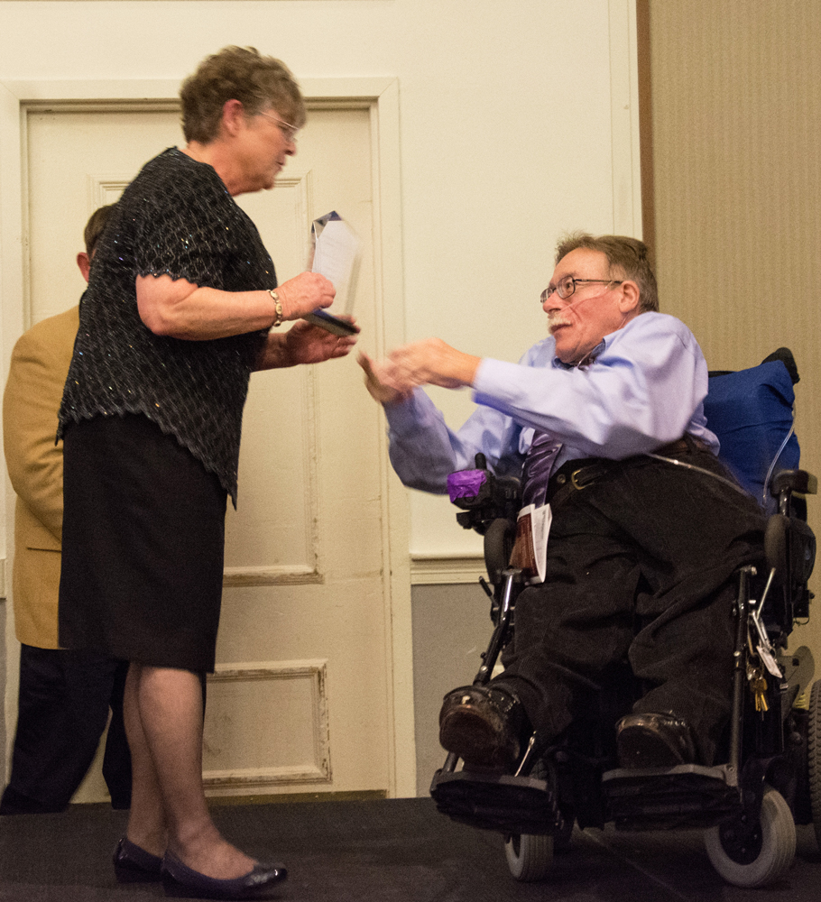 Clare Holgren, wife of Senator Kennedy, accepts his award from Paul